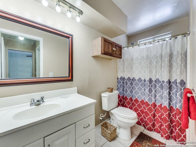 bathroom featuring tile patterned flooring, toilet, and vanity