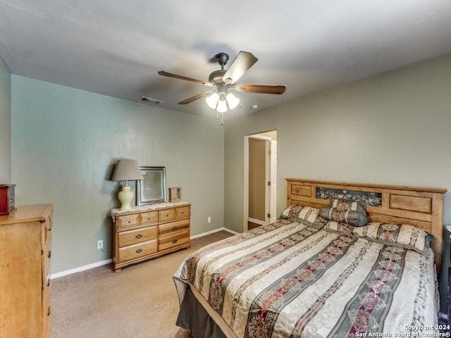 bedroom featuring baseboards, a ceiling fan, visible vents, and light colored carpet