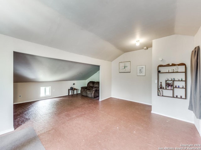 additional living space with lofted ceiling and baseboards