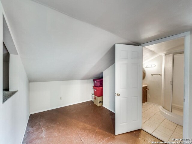 bonus room featuring tile patterned floors and vaulted ceiling