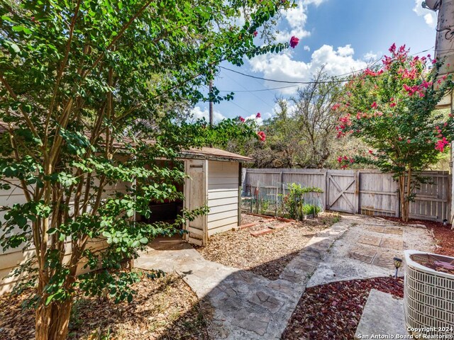 view of yard featuring a storage shed and central air condition unit