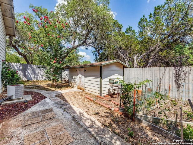 exterior space with an outbuilding, a fenced backyard, and a garden