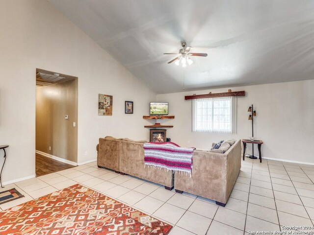 living room featuring ceiling fan, vaulted ceiling, and light tile patterned floors