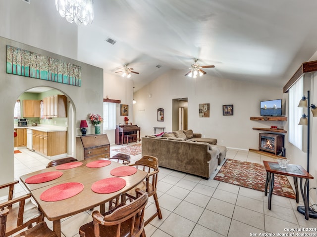 dining space with high vaulted ceiling, ceiling fan with notable chandelier, and light tile patterned floors