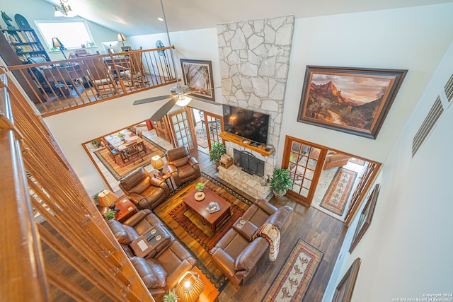 living room featuring high vaulted ceiling, a fireplace, ceiling fan, and hardwood / wood-style flooring