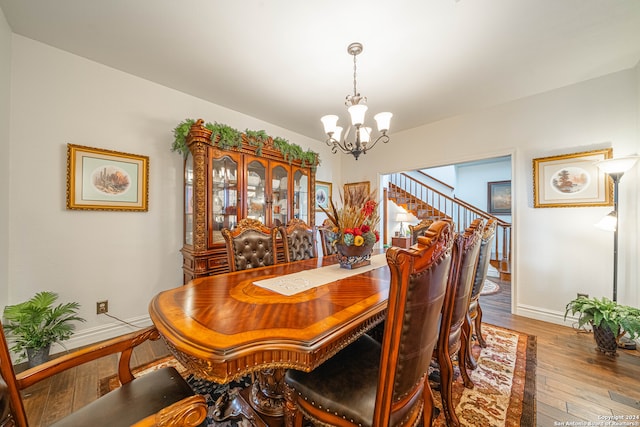 dining area with hardwood / wood-style flooring and a chandelier