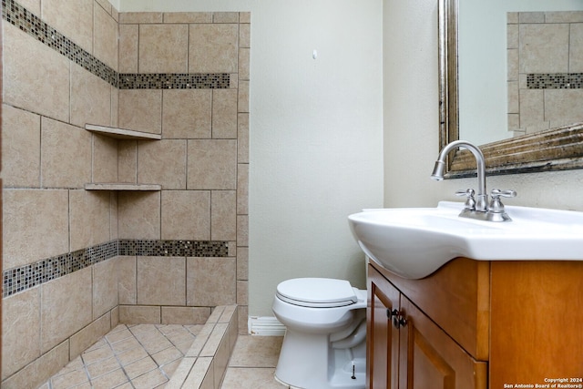 bathroom with tile patterned floors, vanity, toilet, and a tile shower