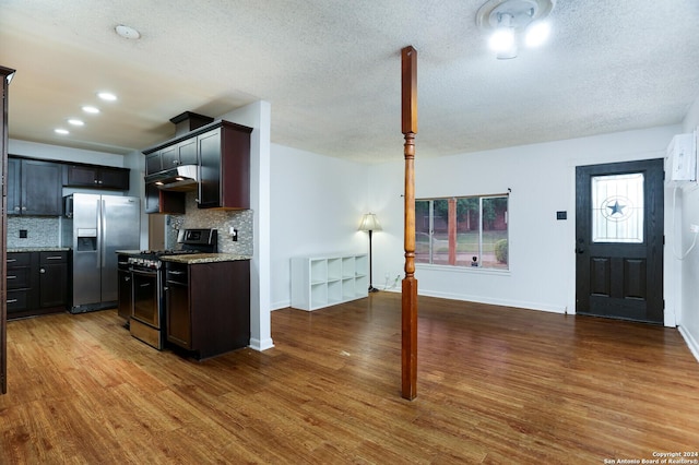 kitchen with tasteful backsplash, light stone countertops, stainless steel appliances, and hardwood / wood-style flooring