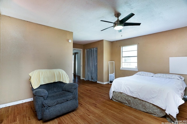 bedroom featuring hardwood / wood-style floors, a textured ceiling, and ceiling fan