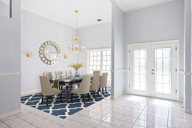 tiled dining room featuring crown molding, french doors, a chandelier, and a towering ceiling