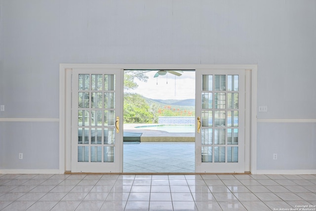 doorway to outside with a mountain view and light tile patterned floors