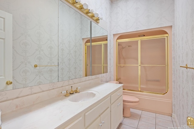 full bathroom with tile patterned flooring, vanity, combined bath / shower with glass door, and toilet