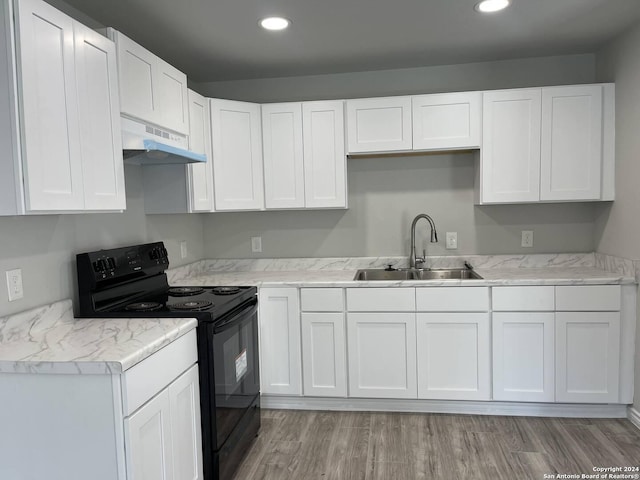 kitchen with black range with electric stovetop, light hardwood / wood-style flooring, sink, and white cabinets