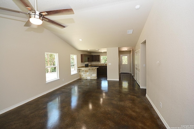 unfurnished living room with concrete flooring, lofted ceiling, baseboards, and a ceiling fan