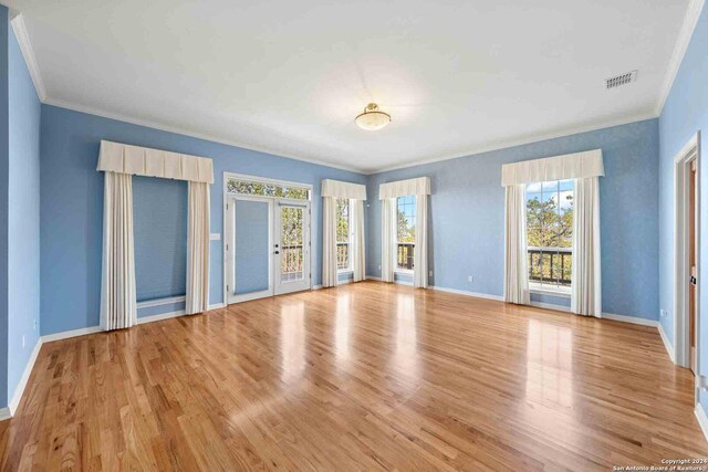 spare room featuring ornamental molding, french doors, and light wood-type flooring