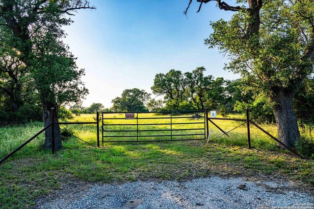 view of gate with a lawn