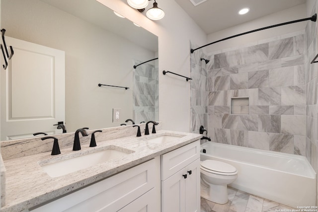 full bathroom featuring tiled shower / bath combo, toilet, and vanity