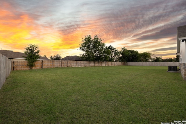 yard at dusk featuring central AC unit