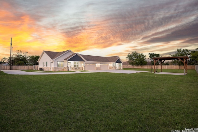 ranch-style home with a gazebo, a garage, and a lawn