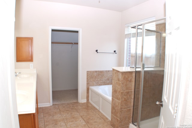 bathroom featuring independent shower and bath, double sink vanity, and tile patterned flooring