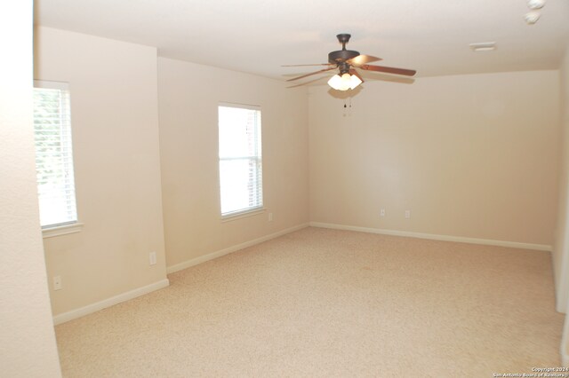 carpeted spare room featuring ceiling fan