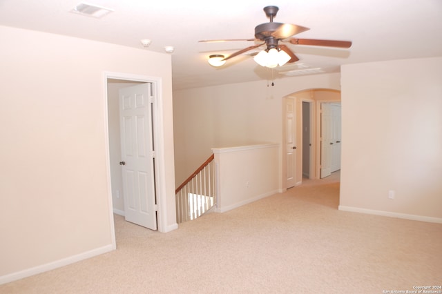 unfurnished room with light colored carpet and ceiling fan