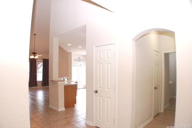 corridor featuring sink and light tile patterned floors