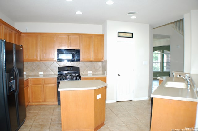 kitchen with a center island, sink, tasteful backsplash, and black appliances