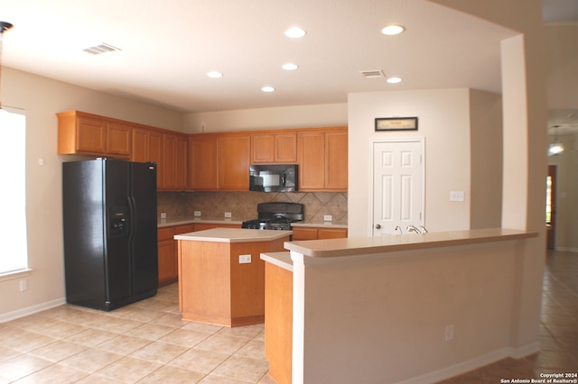 kitchen with backsplash, black appliances, a center island with sink, and light tile patterned floors