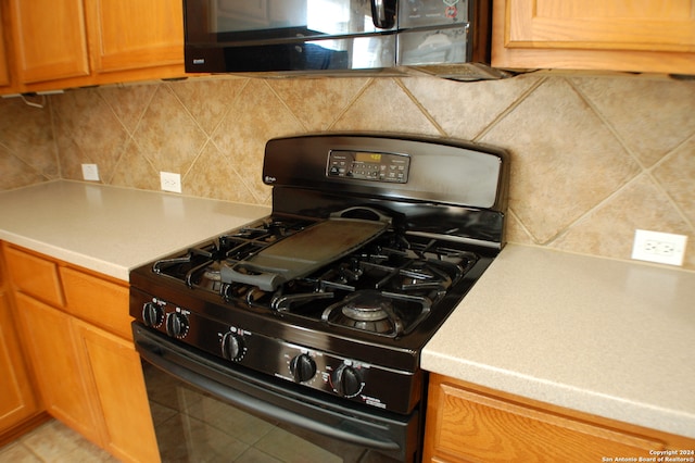 kitchen with tasteful backsplash and black gas stove