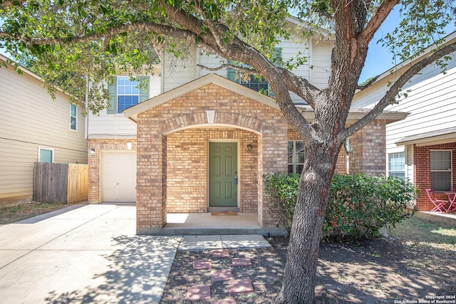 view of front of property featuring concrete driveway, fence, and brick siding