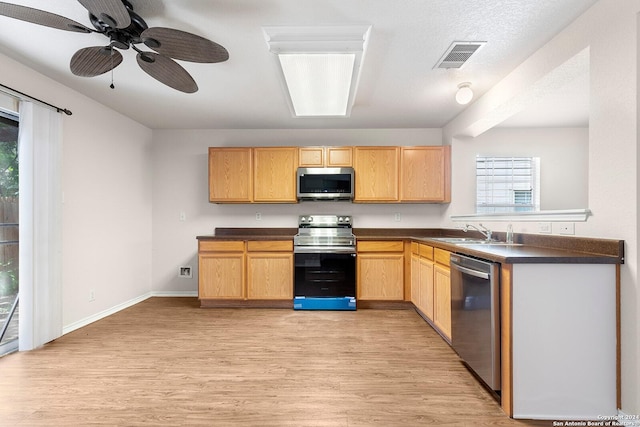 kitchen featuring dark countertops, visible vents, light brown cabinets, appliances with stainless steel finishes, and light wood-style floors