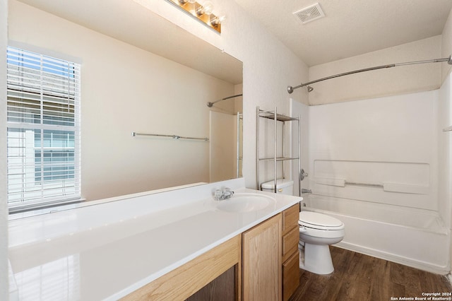 full bathroom featuring vanity, wood finished floors, visible vents, shower / bathing tub combination, and toilet