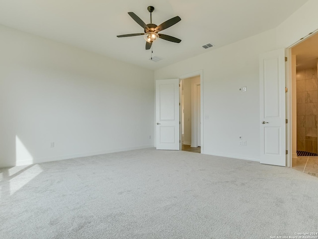 empty room featuring ceiling fan and light carpet