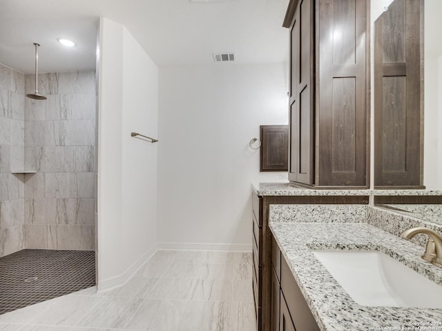 bathroom featuring tiled shower and vanity