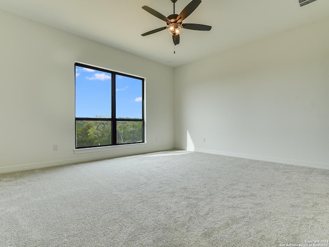 carpeted spare room featuring ceiling fan