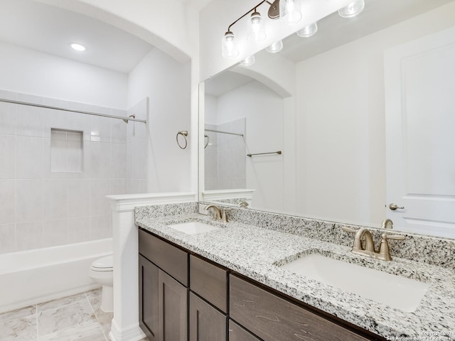 full bathroom featuring toilet, vanity, and tiled shower / bath combo