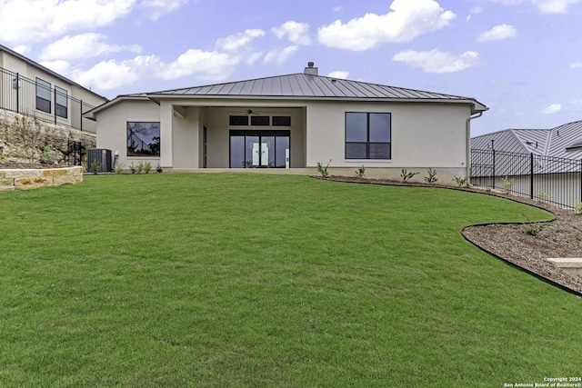 back of house featuring ceiling fan, a lawn, and central AC