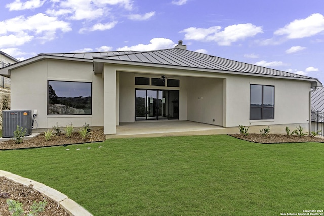 rear view of house featuring central air condition unit, a patio area, and a yard