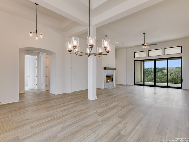 unfurnished living room with light hardwood / wood-style floors, a high ceiling, and ceiling fan