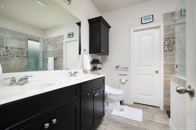 bathroom with tile patterned floors, vanity, toilet, and a shower with shower door