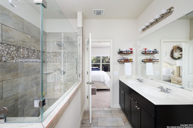 bathroom with tile patterned floors, vanity, and a tile shower