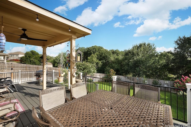 wooden deck with ceiling fan and a yard