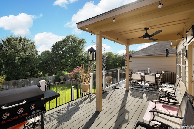 wooden terrace with grilling area, ceiling fan, and a lawn