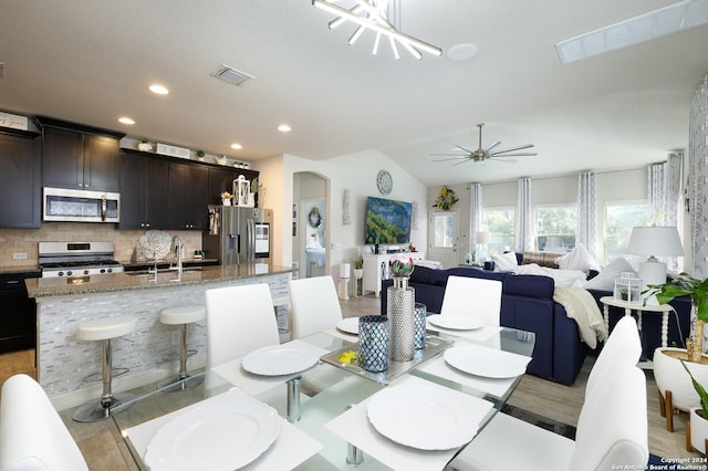 dining room featuring vaulted ceiling, ceiling fan, and sink