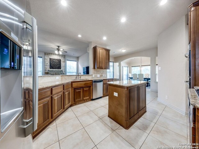 kitchen with light stone countertops, backsplash, and stainless steel appliances