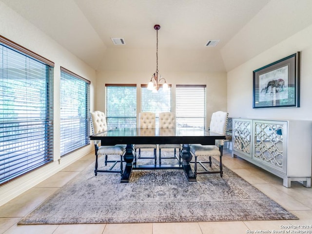 dining area with tile patterned flooring, visible vents, lofted ceiling, and an inviting chandelier