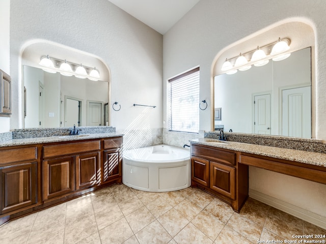 bathroom with lofted ceiling, vanity, tile patterned flooring, and a bathtub