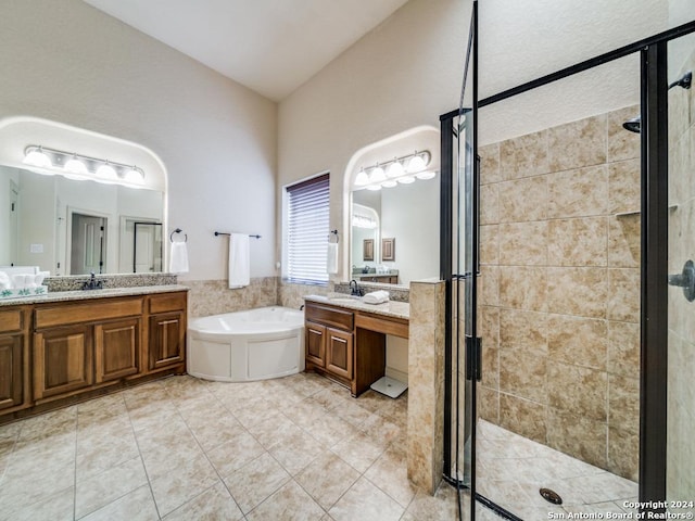 full bath with tile patterned floors, a garden tub, two vanities, a sink, and a shower stall