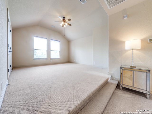 carpeted empty room with lofted ceiling and ceiling fan